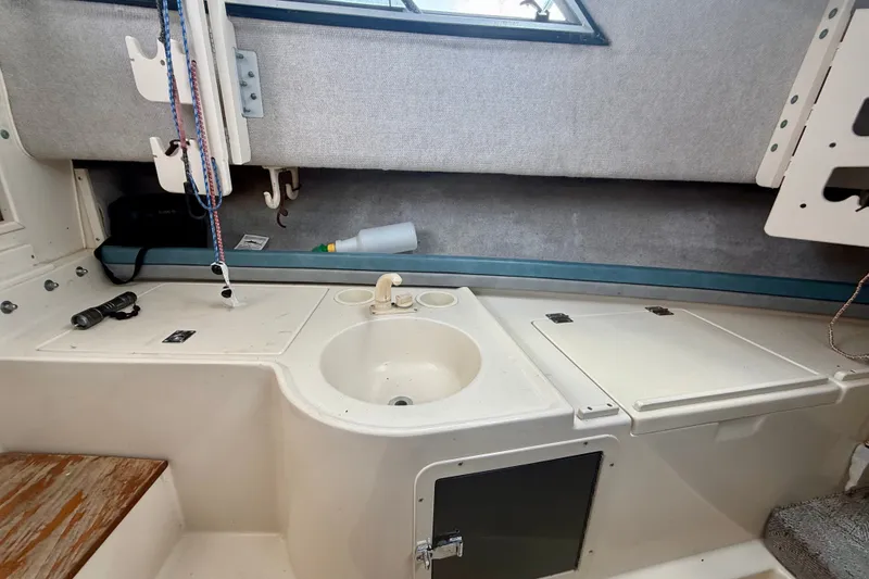 Slide: The Image of 1993 Grady-White Dolphin 250 boat interior with sink and storage compartments. - 9