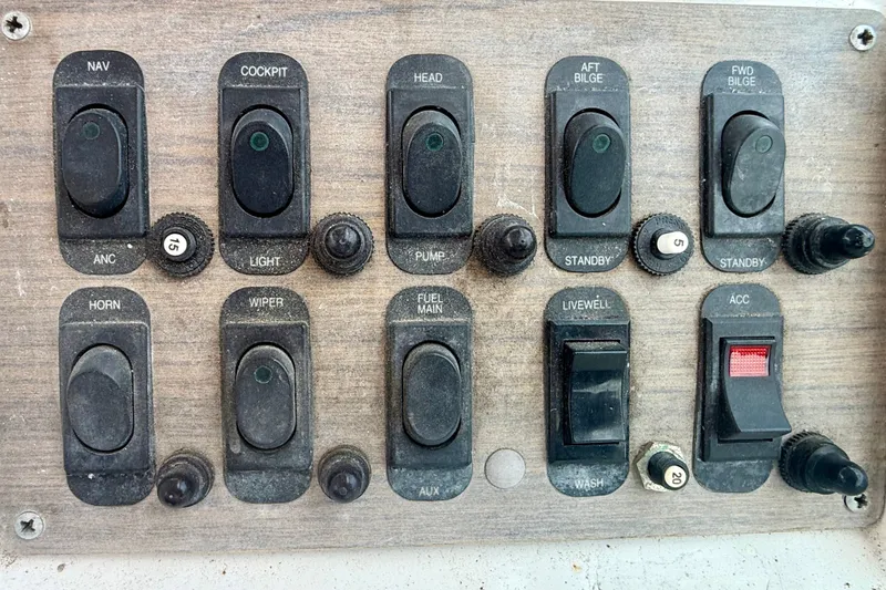 Slide: The Image of Control panel of a 1993 Grady-White Dolphin 250 boat with various switches. - 12