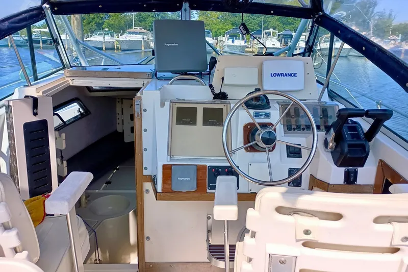 Slide: The Image of 1993 Grady-White Dolphin 250 boat cockpit with steering wheel and navigation equipment. - 1