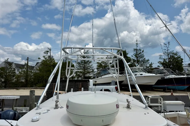 Slide: The Image of 1993 Grady-White Dolphin 250 boat with radar, docked under a cloudy sky. - 6