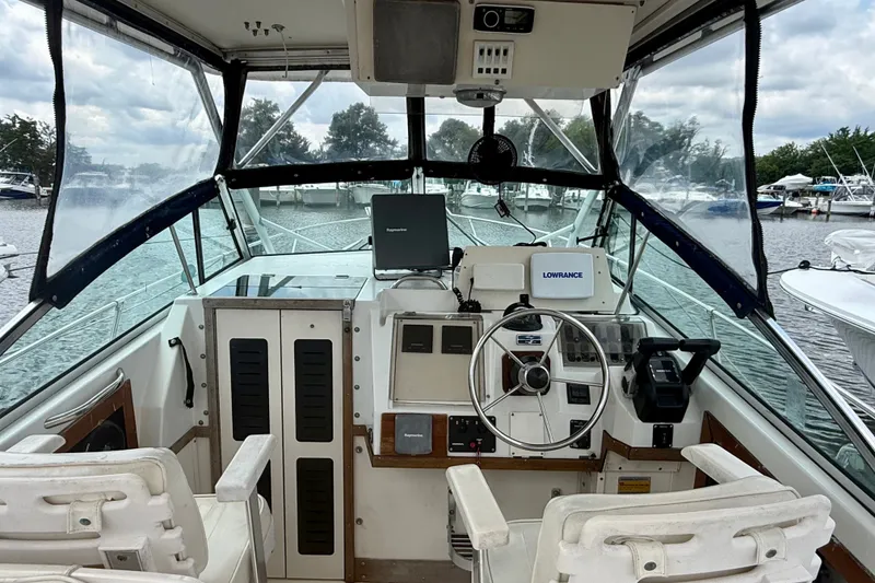 Slide: The Image of Cockpit of 1993 Grady-White Dolphin 250 boat with steering wheel and navigation equipment. - 2