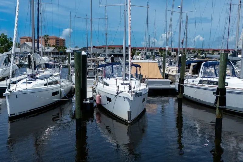 Slide: The Image of 2024 Beneteau Oceanis 34.1 sailboat docked in a marina under a clear blue sky. - 54