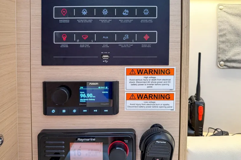 Slide: The Image of Control panel of 2024 Beneteau Oceanis 34.1 yacht with warning labels and radio system. - 21