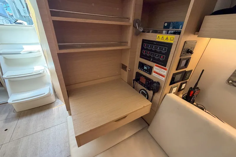 Slide: The Image of 2024 Beneteau Oceanis 34.1 interior with navigation panel and wooden shelving. - 20