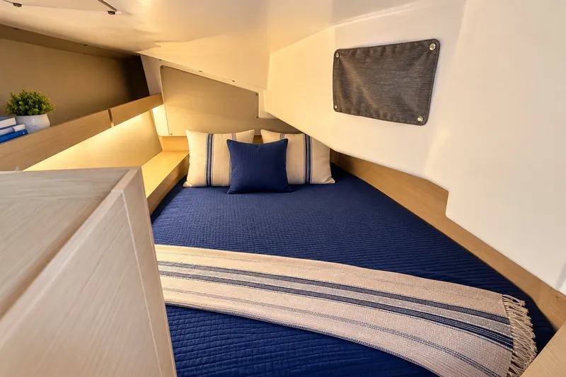 Slide: The Image of Cozy cabin interior of 2024 Beneteau Oceanis 34.1 with blue bedding and modern decor. - 9