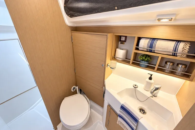 Slide: The Image of 2024 Beneteau Oceanis 34.1 yacht bathroom with modern fixtures and wooden cabinetry. - 10
