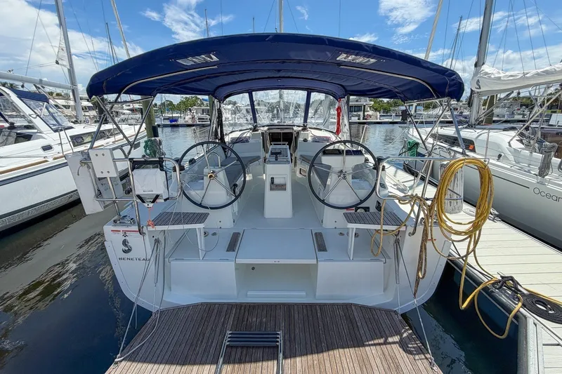 Slide: The Image of 2024 Beneteau Oceanis 34.1 sailboat with dual steering wheels, docked at a marina. - 32