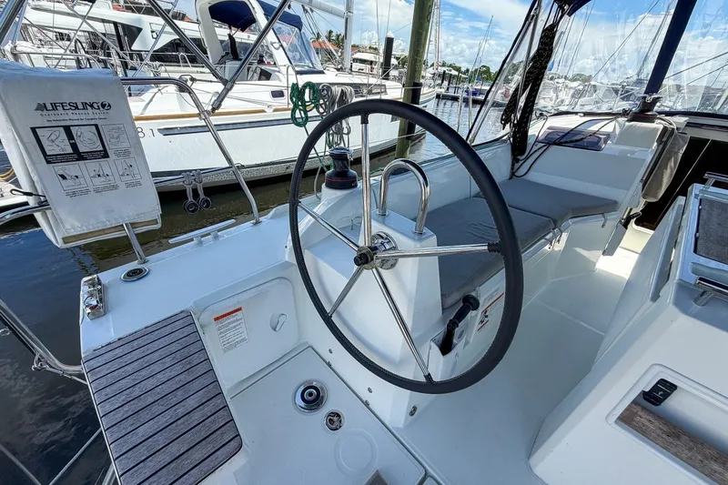 Slide: The Image of 2024 Beneteau Oceanis 34.1 sailboat cockpit with steering wheel and seating area. - 34