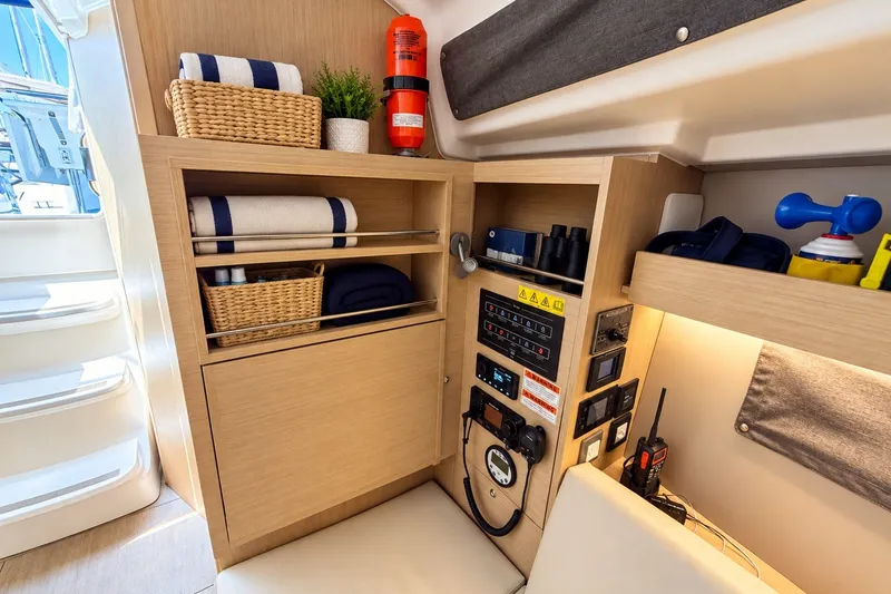 Slide: The Image of 2024 Beneteau Oceanis 34.1 yacht interior with storage, control panel, and safety equipment. - 17