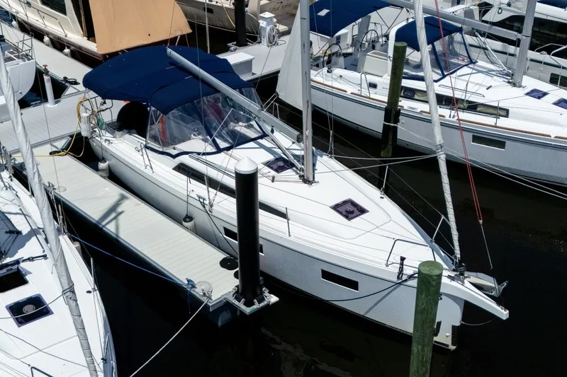 Slide: The Image of 2024 Beneteau Oceanis 34.1 sailboat docked at marina, featuring sleek design and blue canopy. - 56