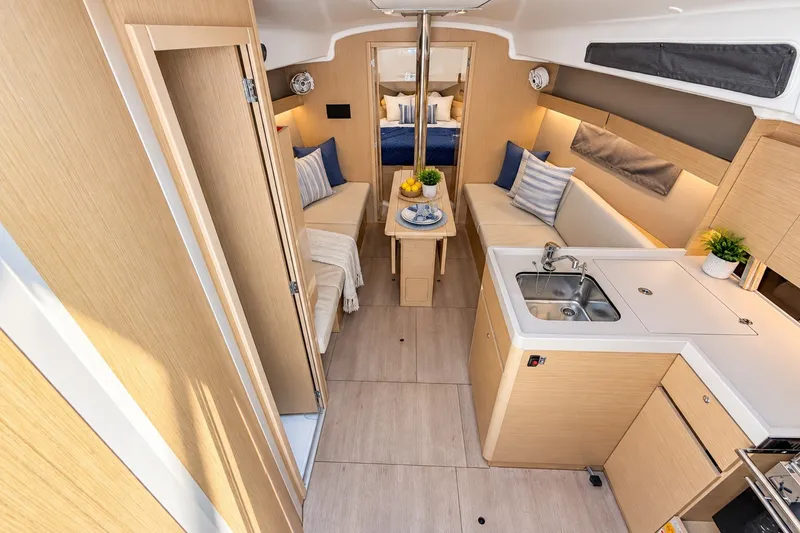 Slide: The Image of 2024 Beneteau Oceanis 34.1 interior with modern kitchen and cozy seating area. - 2