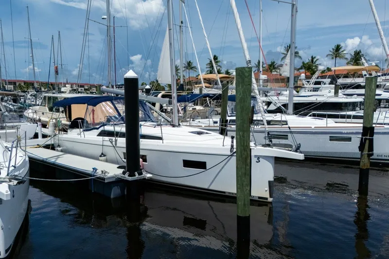 Slide: The Image of 2024 Beneteau Oceanis 34.1 sailboat docked in a marina under a clear blue sky. - 55