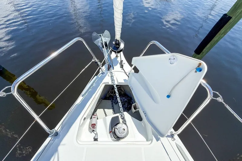 Slide: The Image of 2024 Beneteau Oceanis 34.1 yacht anchor system with open hatch, docked on calm water. - 45