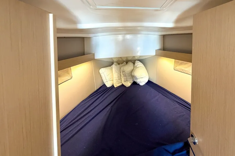 Slide: The Image of Cozy cabin interior of 2024 Beneteau Oceanis 34.1 sailboat with pillows and soft lighting. - 23