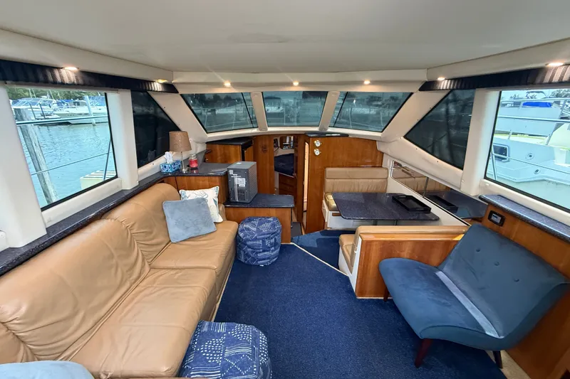 Slide: The Image of Interior of 2002 Carver 404 Cockpit Motor Yacht with cozy seating and large windows. - 34