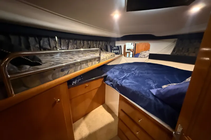 Slide: The Image of Cozy cabin interior of 2002 Carver 404 Cockpit Motor Yacht with bunk beds and storage. - 53