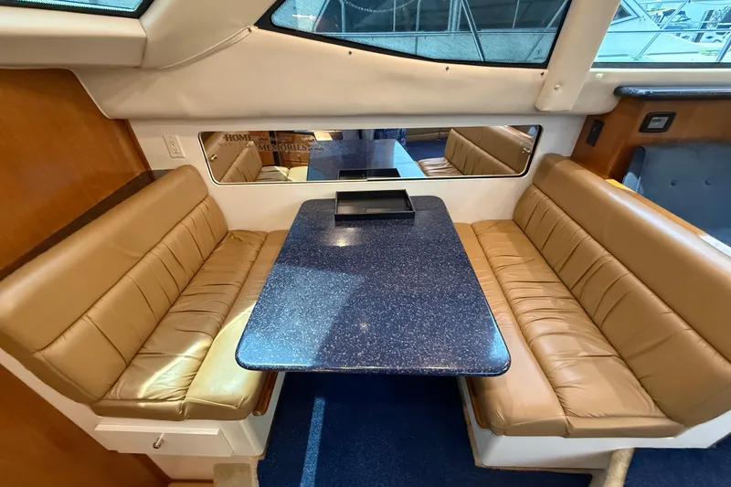 Slide: The Image of Interior of 2002 Carver 404 Cockpit Motor Yacht with tan seating and blue table. - 40