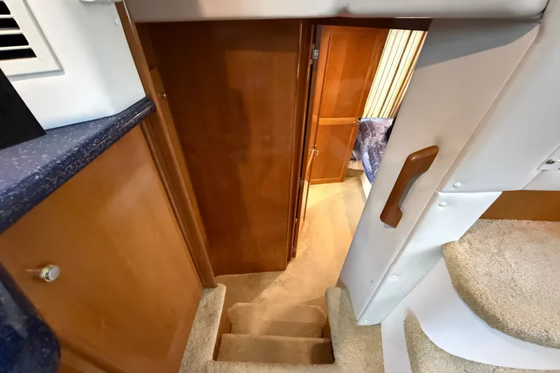 Slide: The Image of Interior view of 2002 Carver 404 Cockpit Motor Yacht, featuring stairs and wooden cabinetry. - 58