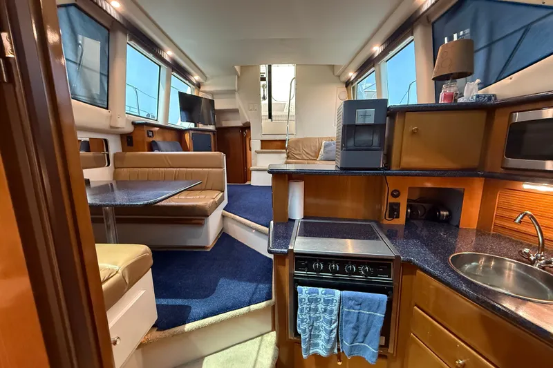 Slide: The Image of Luxurious interior of 2002 Carver 404 Cockpit Motor Yacht with modern kitchen and seating area. - 42