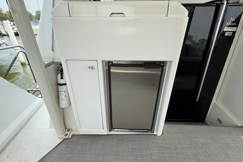 Slide: The Image of 2002 Carver 404 Cockpit Motor Yacht interior with mini fridge and fire extinguisher. - 16