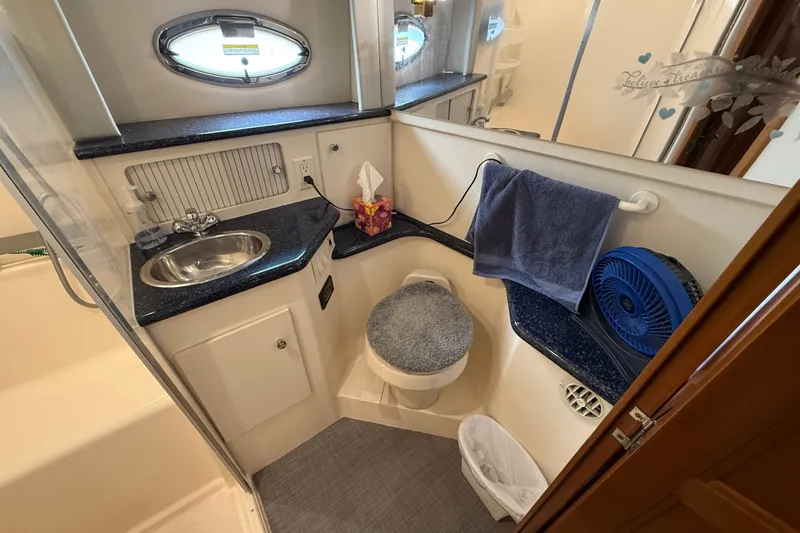 Slide: The Image of 2002 Carver 404 Cockpit Motor Yacht bathroom with sink, toilet, and towel. - 63