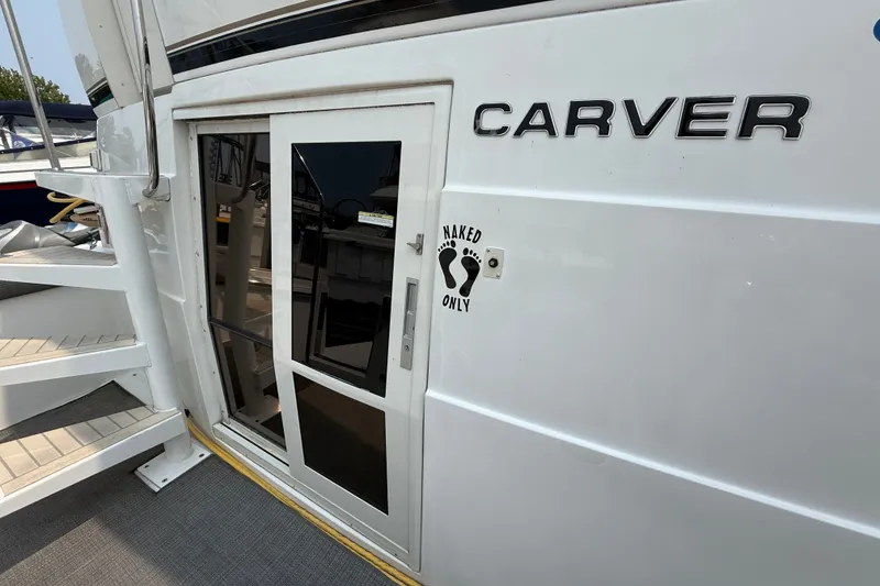 Slide: The Image of 2002 Carver 404 Cockpit Motor Yacht with "Naked Only" sign near entrance. - 7