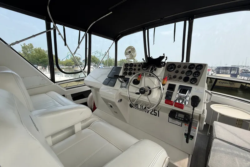 Slide: The Image of Interior view of 2002 Carver 404 Cockpit Motor Yacht helm with steering wheel and controls. - 21