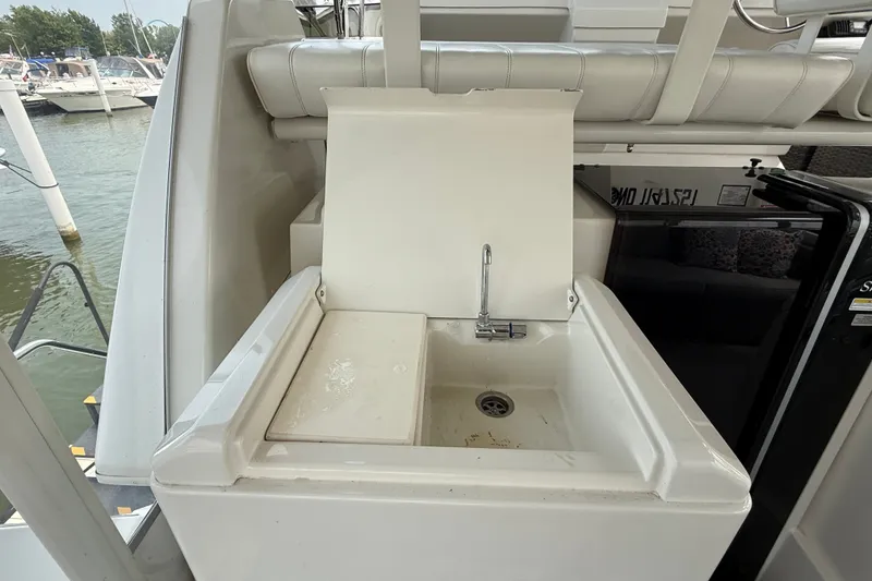 Slide: The Image of 2002 Carver 404 Cockpit Motor Yacht sink area with faucet, docked at marina. - 17