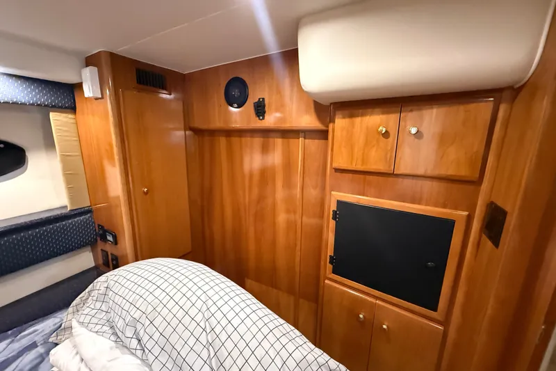 Slide: The Image of Interior of 2002 Carver 404 Cockpit Motor Yacht with wood cabinetry and cozy bedding. - 61