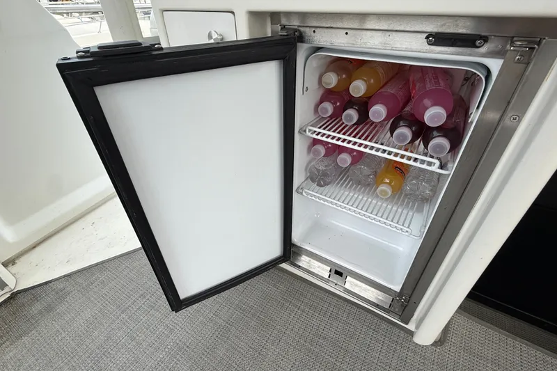 Slide: The Image of Open fridge on 2002 Carver 404 Cockpit Motor Yacht, stocked with assorted beverages. - 19