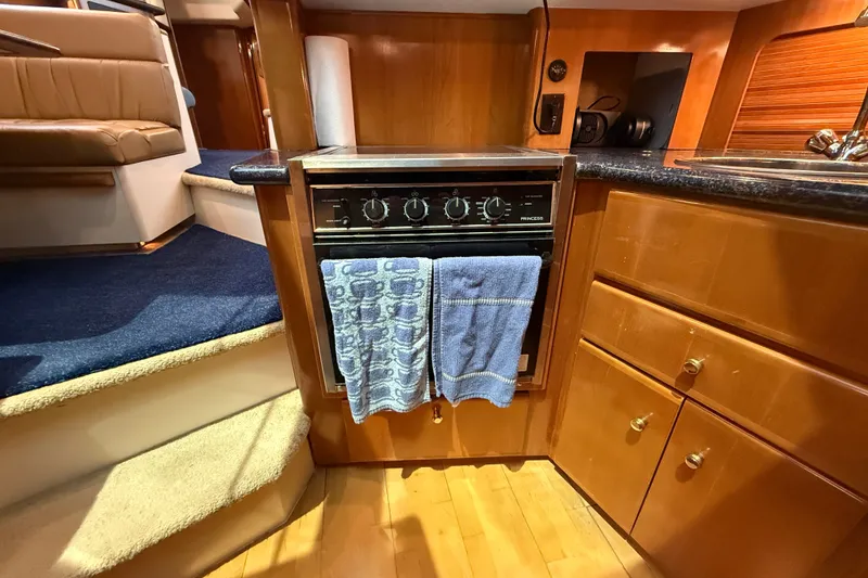Slide: The Image of Interior of 2002 Carver 404 Cockpit Motor Yacht kitchen with stove and cabinetry. - 44
