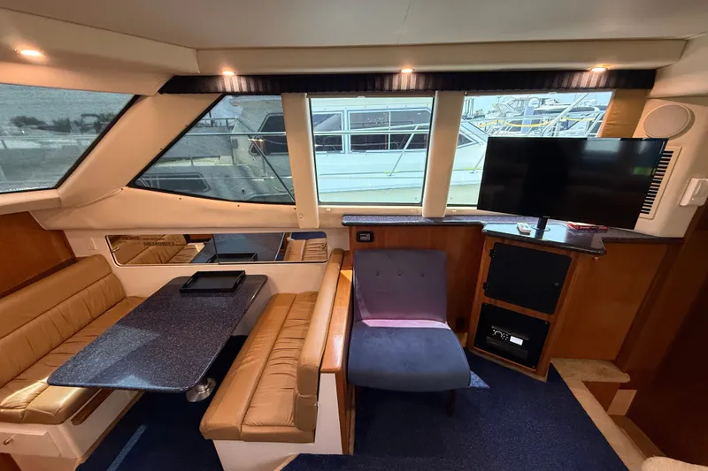 Slide: The Image of Interior of 2002 Carver 404 Cockpit Motor Yacht with seating, table, and TV. - 36