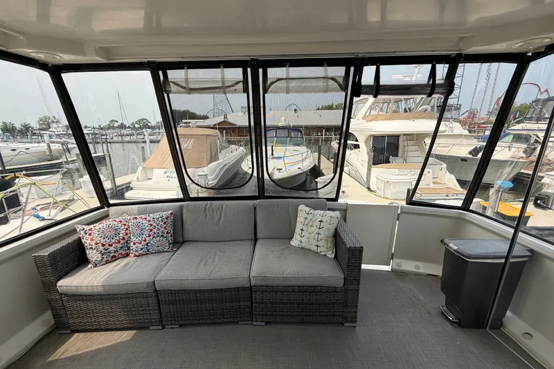 Slide: The Image of Interior view of 2002 Carver 404 Cockpit Motor Yacht with comfortable seating and marina backdrop. - 11