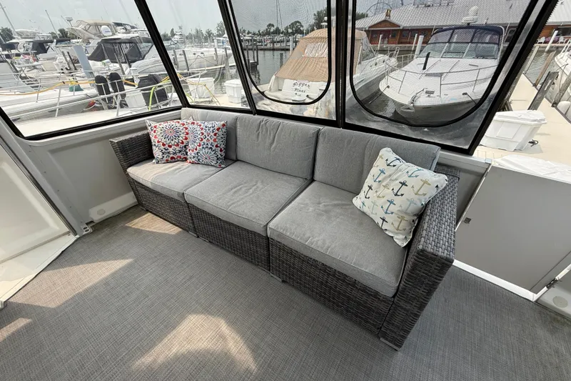 Slide: The Image of Luxurious 2002 Carver 404 Cockpit Motor Yacht interior with comfortable seating and decorative pillows. - 10