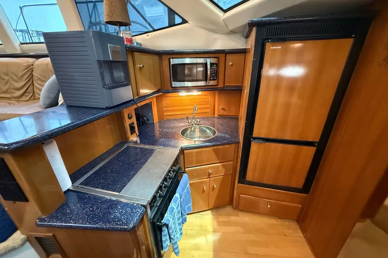 Slide: The Image of Interior of 2002 Carver 404 Cockpit Motor Yacht kitchen with appliances and wood cabinetry. - 43