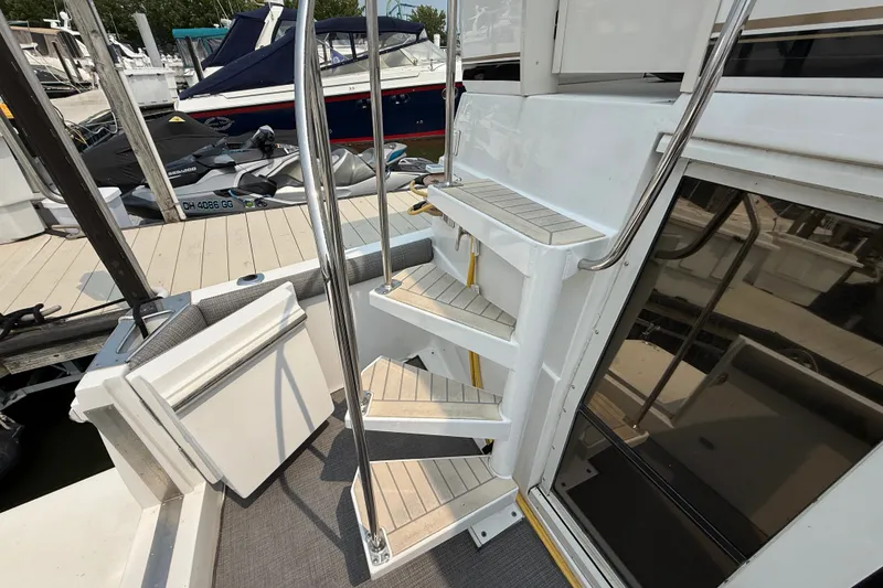 Slide: The Image of Staircase on 2002 Carver 404 Cockpit Motor Yacht, docked with visible watercraft nearby. - 8