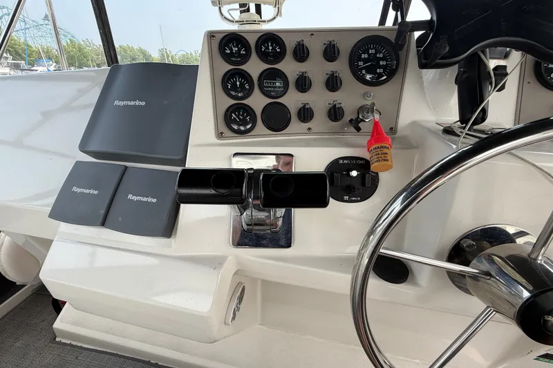Slide: The Image of 2002 Carver 404 Cockpit Motor Yacht helm with Raymarine navigation equipment and steering wheel. - 26