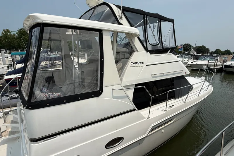 Slide: The Image of 2002 Carver 404 Cockpit Motor Yacht docked at marina, featuring sleek design and spacious cockpit. - 1