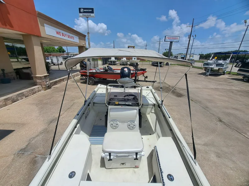 Slide: The Image of A 2022 Ranger RB190 boat with a canopy, parked outside a boat dealership. - 19