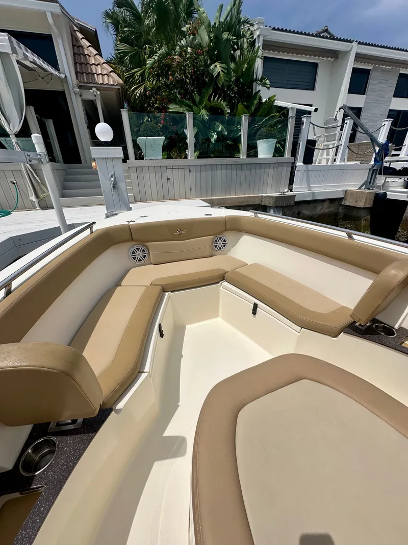 Slide: The Image of The image shows the cockpit of a 2019 Scout 235 XSF boat with beige upholstery. - 3