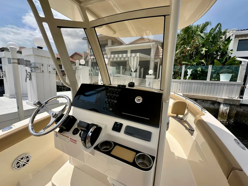Slide: The Image of The image shows the cockpit of a 2019 Scout 235 XSF boat with a modern helm. - 1