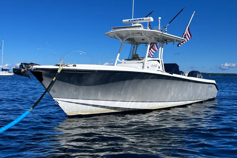 The Image of 2008 Edgewater 318CC boat on water, clear sky, American flags, Furuno equipment. - 2