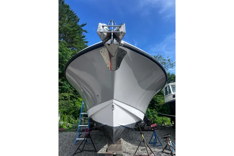 Slide: The Image of 2008 Edgewater 318CC boat on stands, viewed from the front, under a clear blue sky. - 22