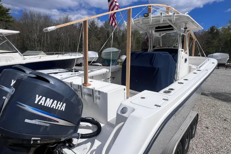 Slide: The Image of 2008 Edgewater 318CC boat with Yamaha engines, parked outdoors under a clear sky. - 6