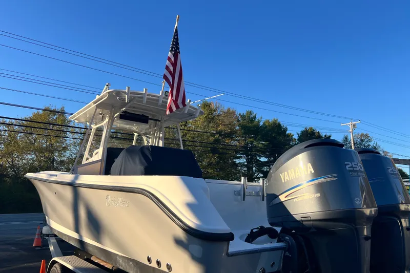 Slide: The Image of 2008 Edgewater 318CC boat with Yamaha engines and American flag, parked outdoors. - 4