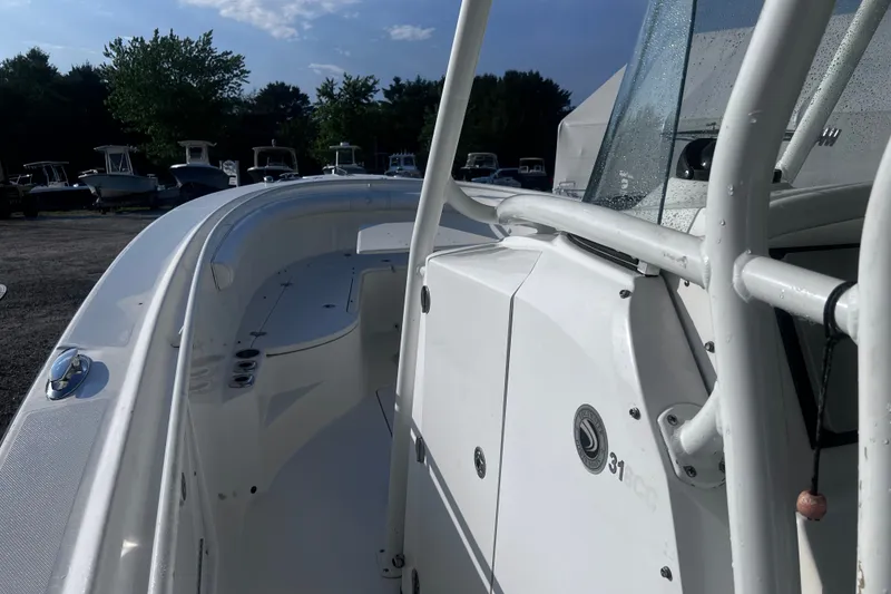 Slide: The Image of 2008 Edgewater 318CC boat, sleek white design, parked outdoors under a clear sky. - 21