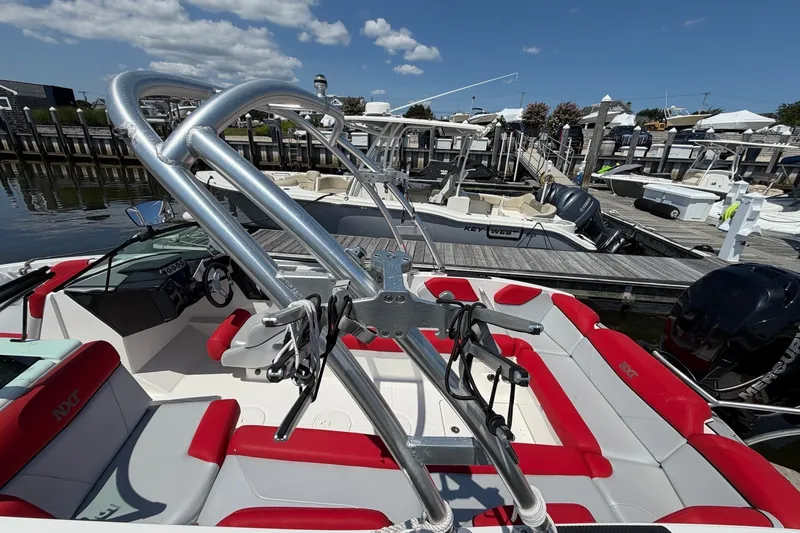 Slide: The Image of 2017 MasterCraft NXT20 Global Edition boat docked, featuring red and white seating and a sleek design. - 5