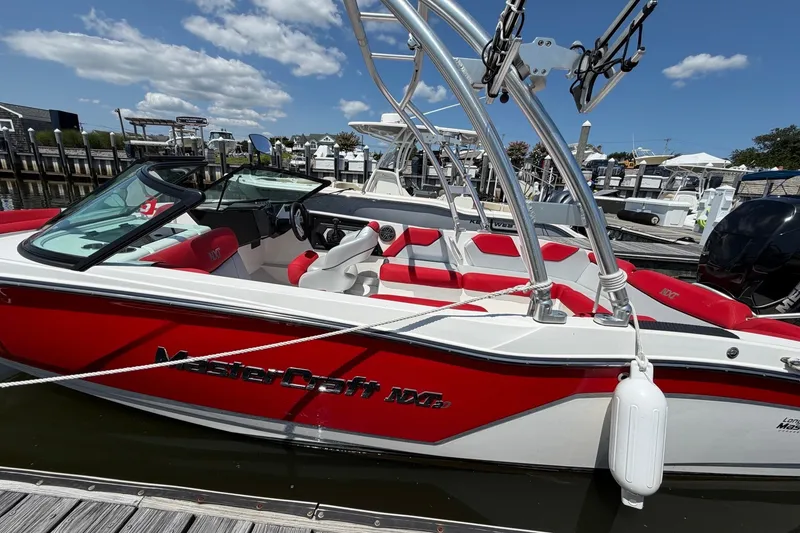 Slide: The Image of 2017 MasterCraft NXT20 Global Edition boat docked, featuring red and white design with wakeboard tower. - 6