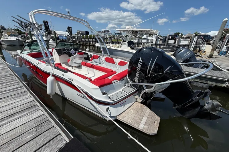 Slide: The Image of 2017 MasterCraft NXT20 Global Edition boat docked, featuring red and white seating, Mercury engine. - 3