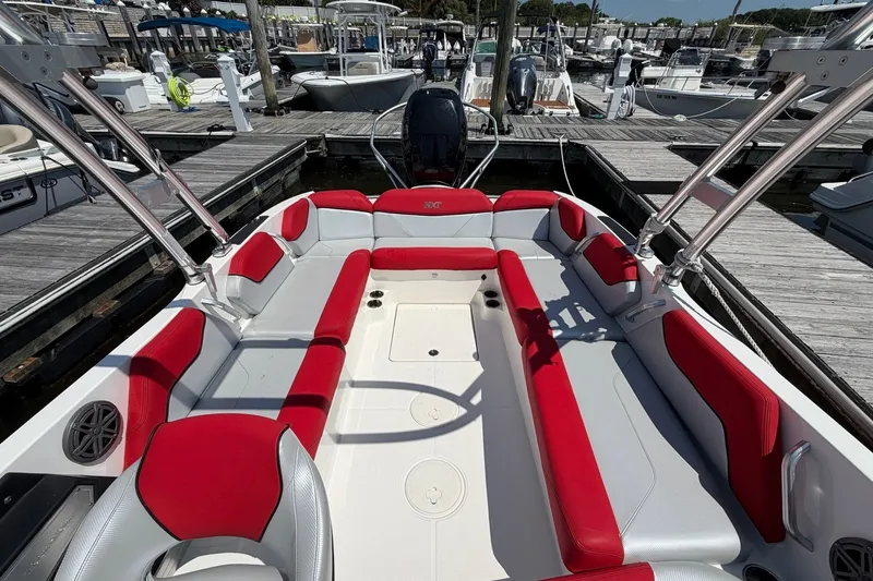 Slide: The Image of 2017 MasterCraft NXT20 Global Edition boat with red and gray seating at a marina. - 7